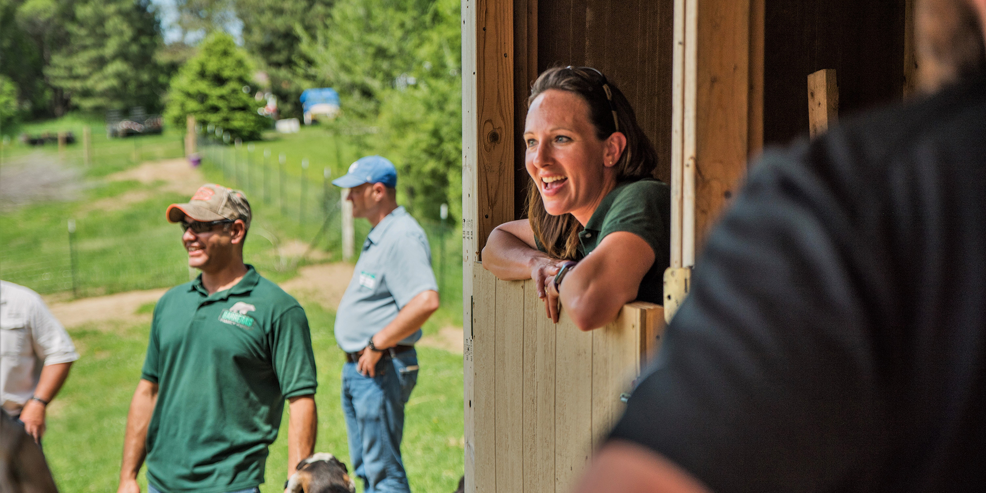Woman leaning out of barn door smiling