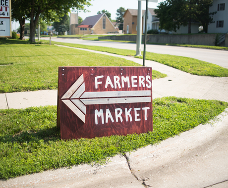 yard sign that says farmers market with a large arrow