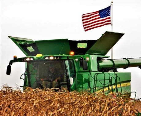 Combine during harvest with American flag