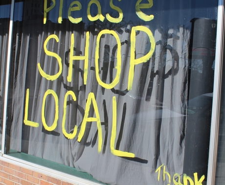 Storefront with painted 'please shop local'