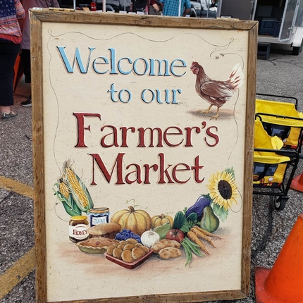 Cartell que diu "Benvinguts al nostre mercat de pagesos"