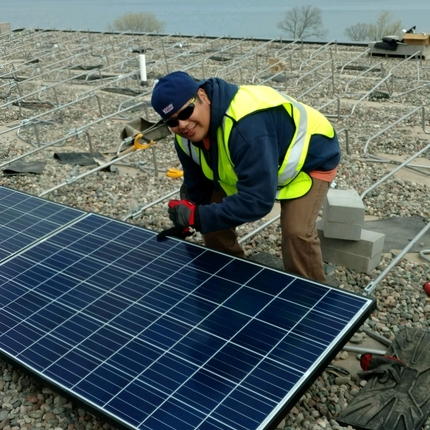 Home treballant en un panell solar