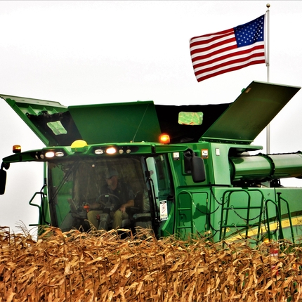 Combine during harvest with American flag