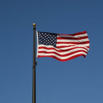 Bandera americana amb onades del vent sobre un fons de cel blau profund sense núvols
