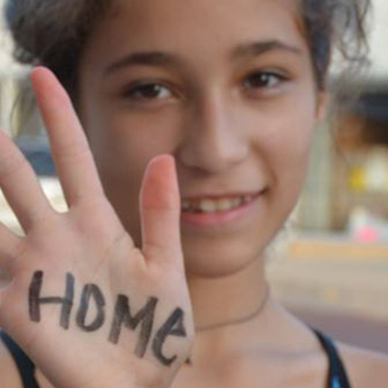 Girl with "home" written on her hand