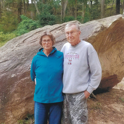 Dona i home de peu davant d’una roca