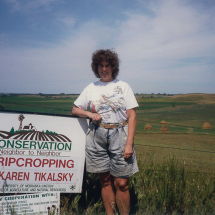 Dona de peu al costat de Conservation sign in field