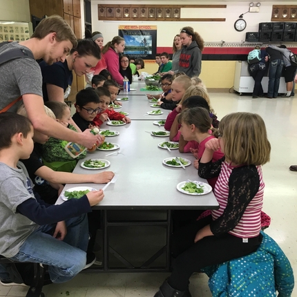 Children at lunch table eating salad